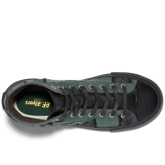 Green sneaker with black laces on a white background