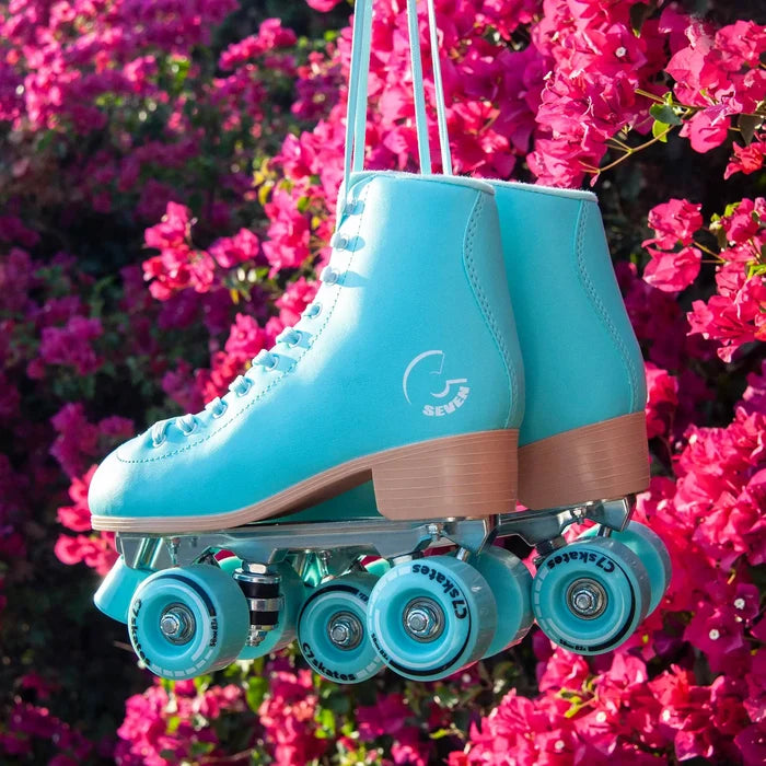 Turquoise roller skate with brown accents hanging against a pink floral background
