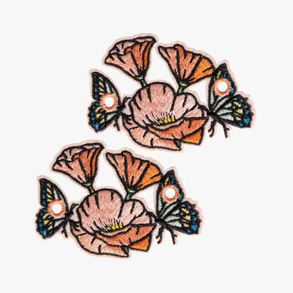 Embroidered Pretty Peach Poppy Field charms on a white background