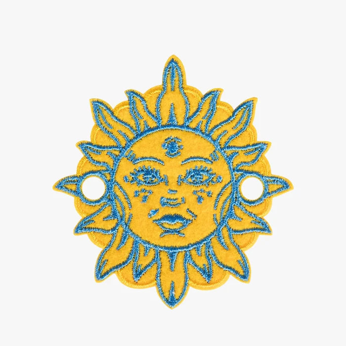 Embroidered charm of a sun with a face on a white background