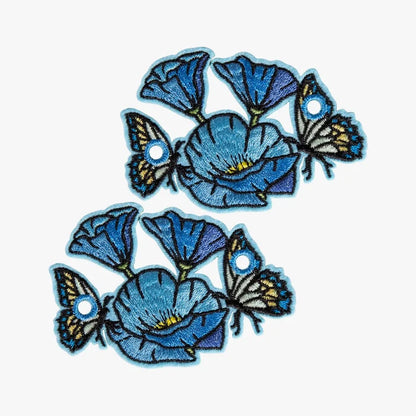 Embroidered blue flowers and butterflies charms on a white background