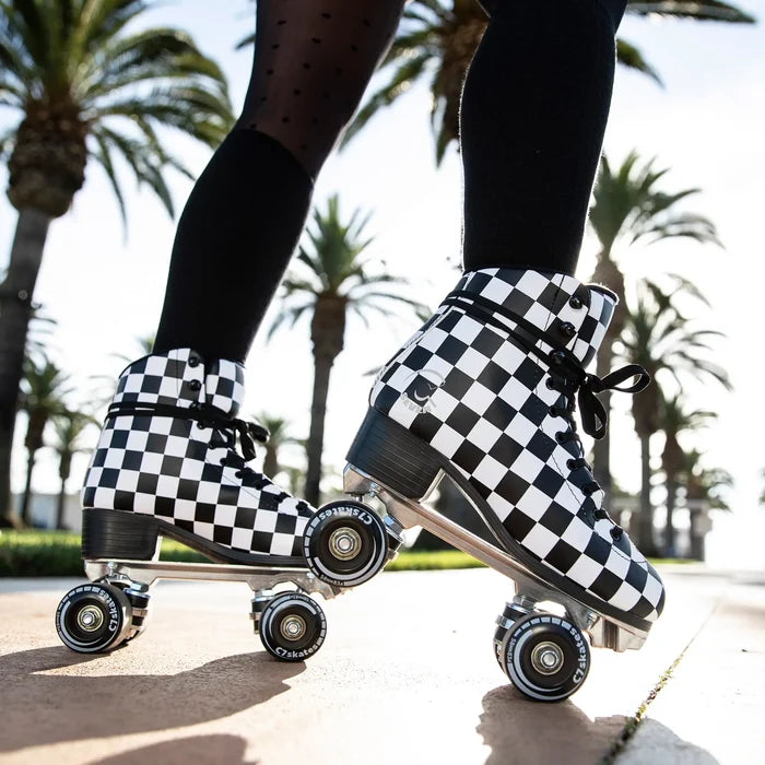 Checkered roller skates on a person with palm trees in the background