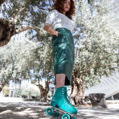 Person roller skating in a park with trees and a building in the background