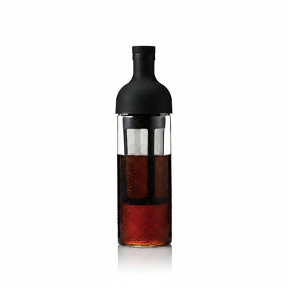 Bottle with a black cap and clear body containing a dark liquid on a white background