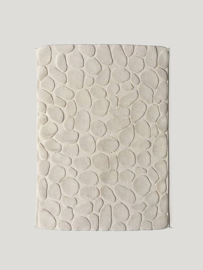 Textured beige bathmat on a light gray background