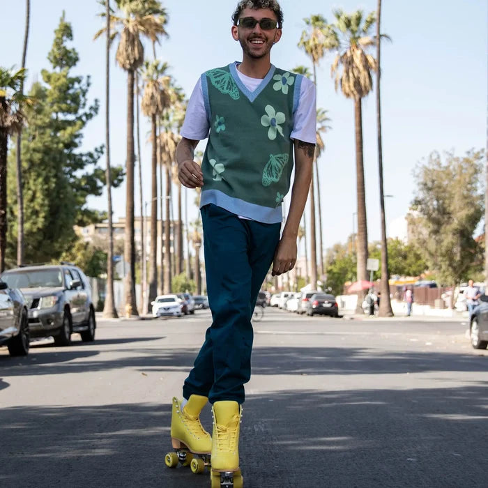 Man rollerblading on a street with palm trees in the background