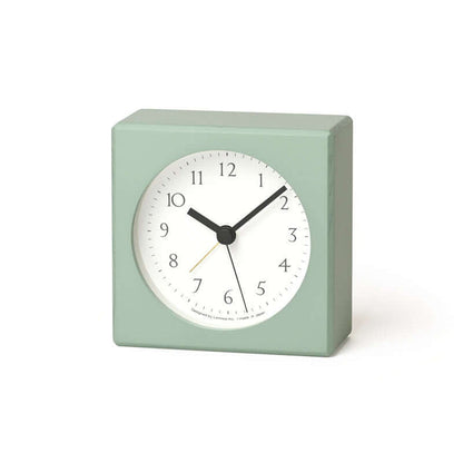 Light green square clock with a white face on a white background