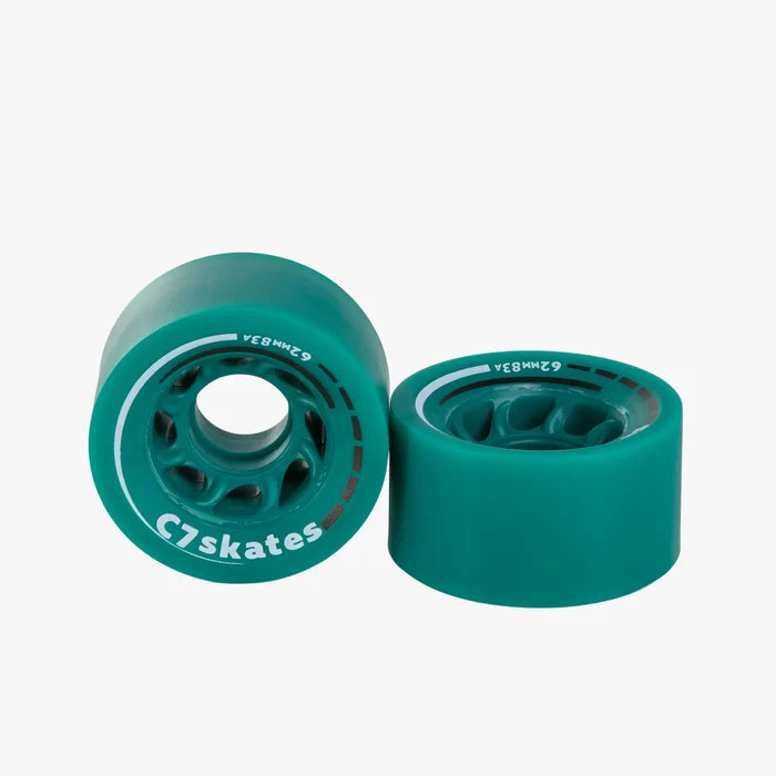 Two green roller skate wheels with white bearings on a white background