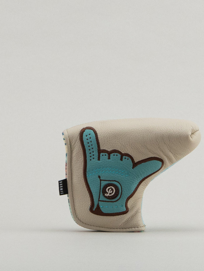 Beige and blue golf club headcover with a glove holding the shaka up