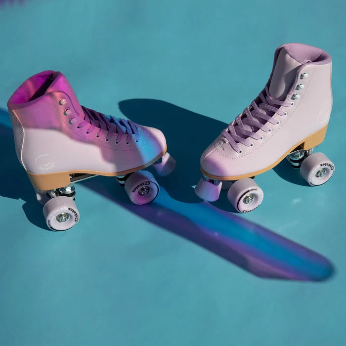 Pair of pastel pink and purple roller skates on a blue background