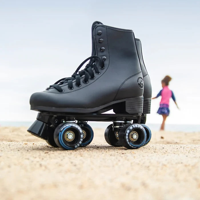 Black roller skate on a sandy surface with a blurred background